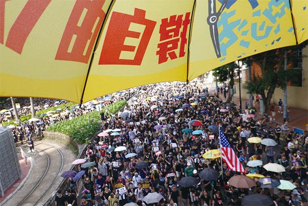 2019年7月21日，香港，民陣發起的反送中遊行隊伍中，有市民打開寫有「撐自由」的黃雨傘。（余鋼／大紀元）