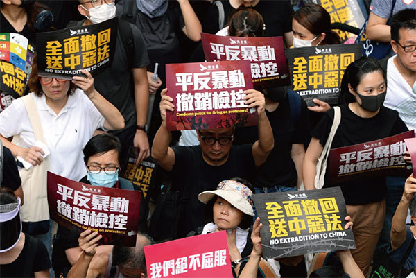 圖3：2019年7月21日，香港，民陣發起的反送中遊行隊伍中，有市民拿著寫有「平反暴動 撤銷檢控」的標語。（宋碧龍／大紀元）